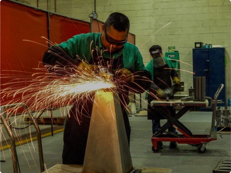 Operator grinding a welded steel part